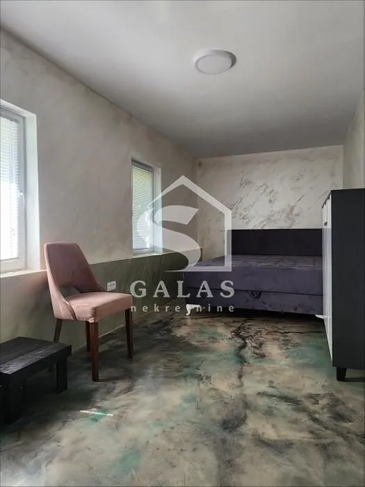 Bedroom with a double bed, a chair and a decorative floor.