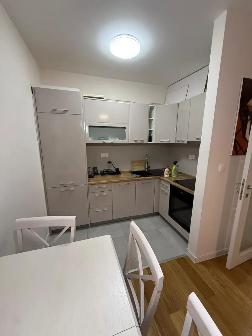 Small equipped kitchen with a dining table in bright tones.