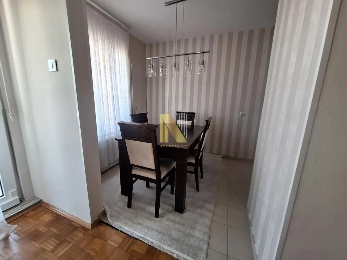 Trpezarija sa stolom i stolicama u stanu.