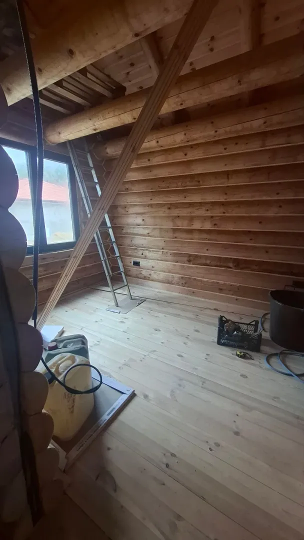 Attic under construction with wooden walls and flooring.
