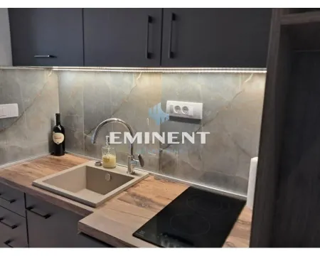 Part of the kitchen with a sink, countertop, and built-in cooktop. - image 6