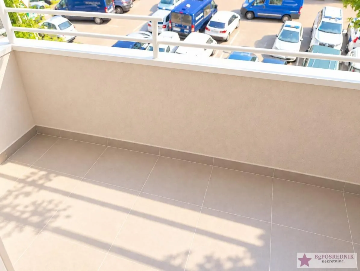Pogled na prostrani otvoreni balkon sa keramičkim pločicama i ogradom.