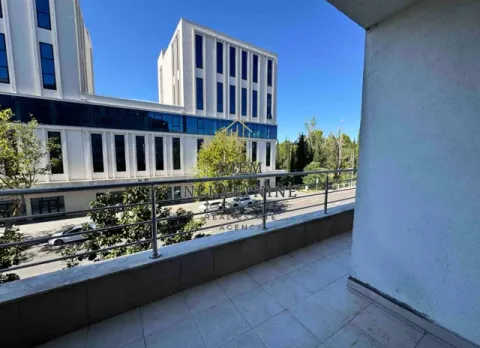 Natkrivena terasa sa pogledom na ulicu i moderne zgrade. - image 9