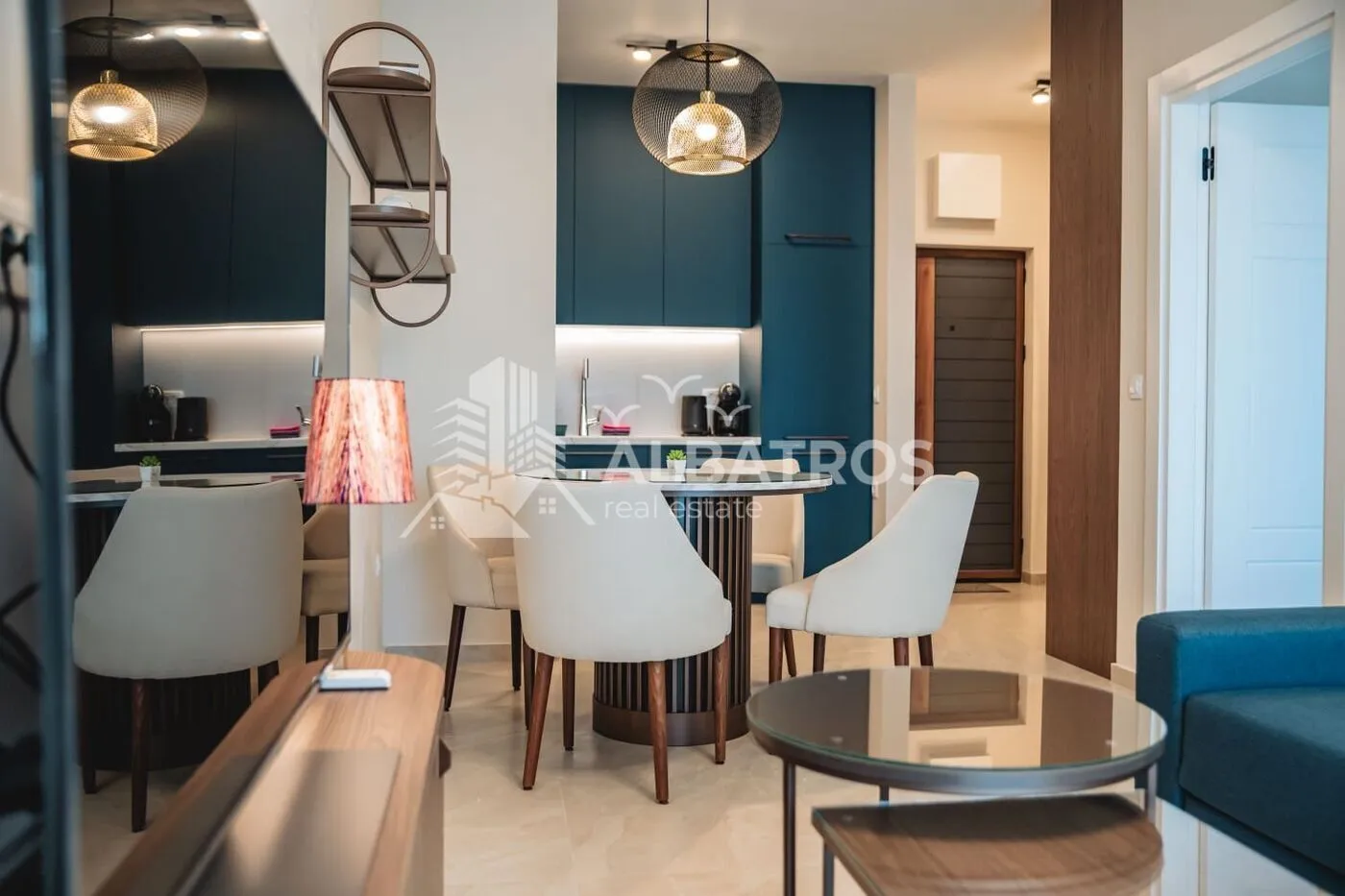 View of the living room with dining area and kitchen in the background.