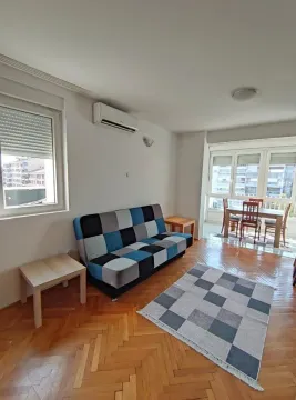Living room with a sofa and a dining area in the background. - image 8