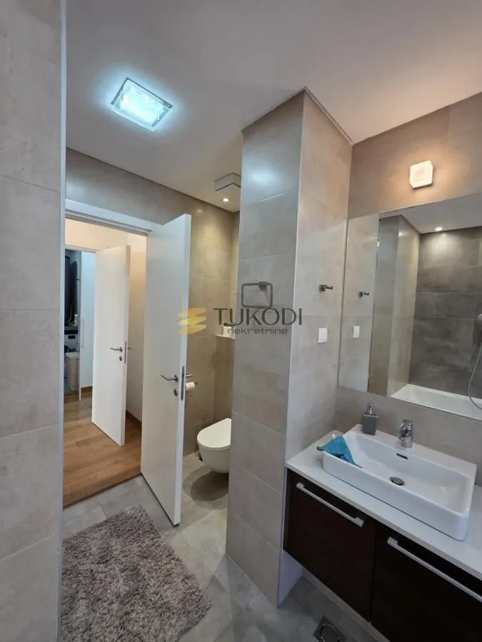 Modern bathroom with a washbasin, mirror, and toilet.
