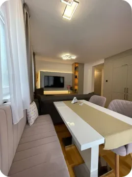 Living room with a dining table and a wall-mounted TV. - image 14