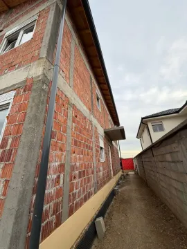 Bočna fasada kuće u izgradnji sa nedovršenom ciglom i krovom. - image 5