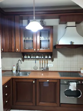 Classic kitchen with wooden cabinets, a sink, and a built-in oven. - image 7