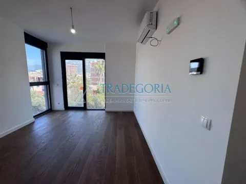 Prazna soba sa drvenim podom, klima uređajem i velikim prozorima. - image 7