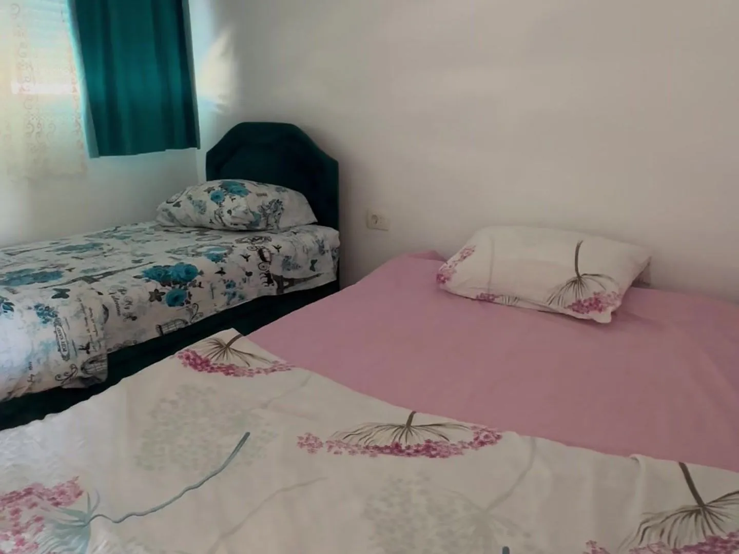 Bedroom with two beds and white walls.