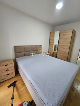 Furnished bedroom with a double bed and wooden wardrobe. - image 5