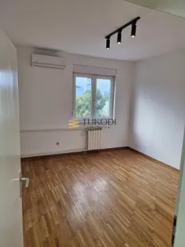Prazna soba sa parketom na podu, klima-uređajem i prozorom. - image 5