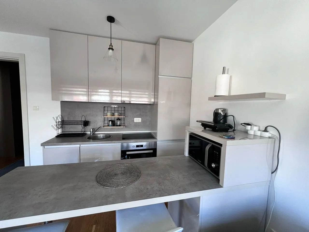 Modern kitchen with light-toned cabinetry and a breakfast bar.