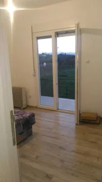 Bright room with large balcony doors and a view of the yard. - image 9