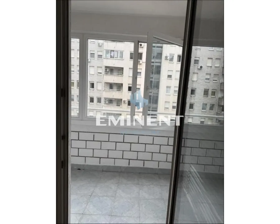 Enclosed balcony with a view of neighboring buildings.