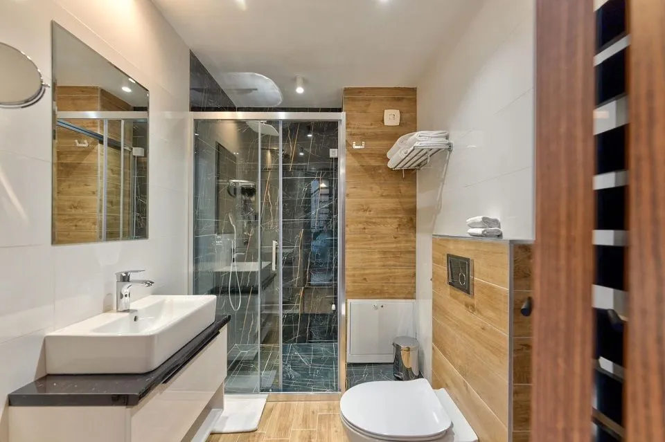 Moderno kupatilo sa tuš kabinom, umivaonikom i wc šoljom.