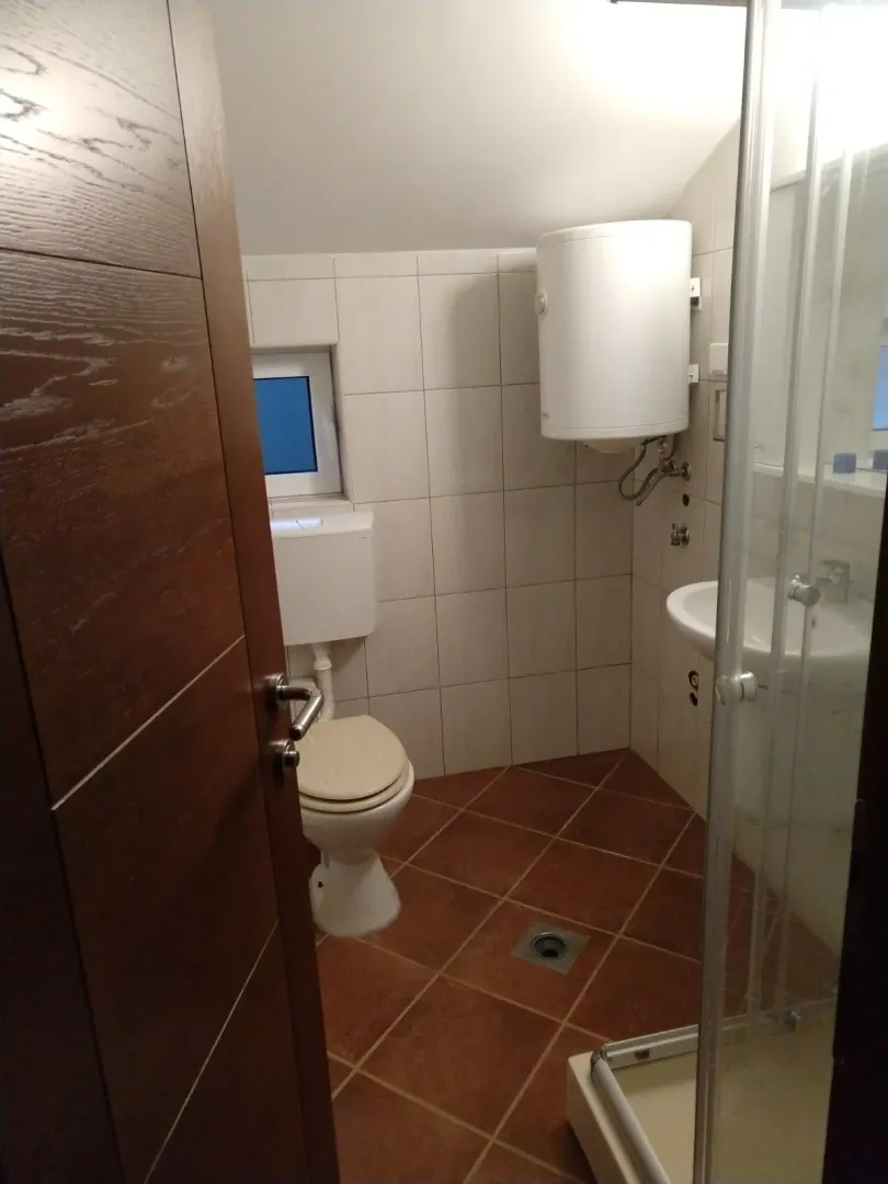 Malo kupatilo sa tuš kabinom i keramičkim pločicama.