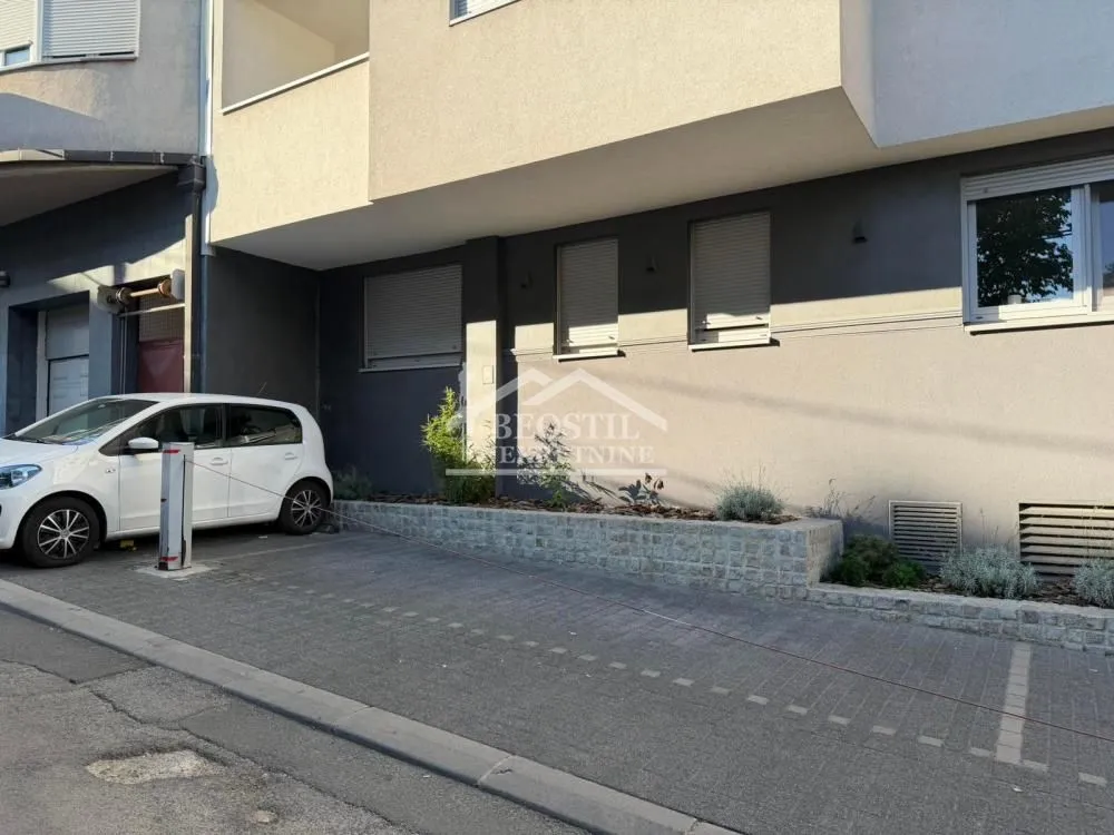 Pogled na spoljašnjost zgrade sa parking mestom.