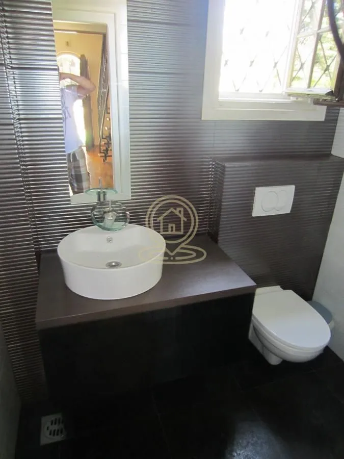 Modernly equipped bathroom with a washbasin and toilet.