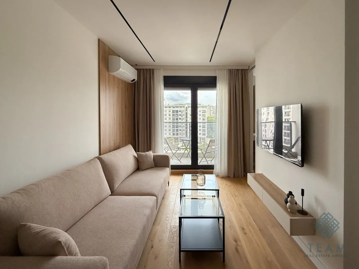 Living room with a sofa, coffee table, and wall-mounted TV.
