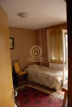Manja spavaća soba sa krevetom, stolicom i prozorom koji gleda na spoljašnji prostor. - image 7