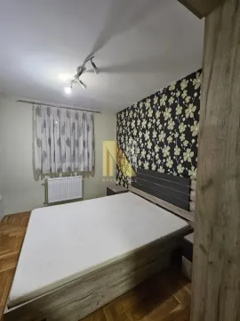 Nameštena spavaća soba sa bračnim krevetom i tapetom na zidu. - image 8