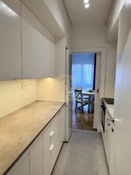 Moderna bela kuhinja sa radnom površinom i ugradnim elementima. - image 8