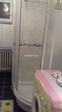 Smaller bathroom with a shower cabin and a washing machine. - image 9