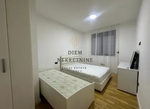 Furnished bedroom with two beds and a white wardrobe. - image 6