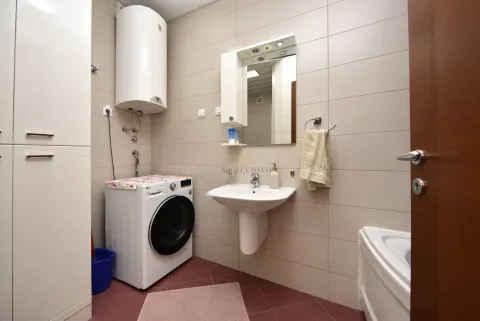 Bathroom with a washbasin, washing machine, water heater, and a mirror. - image 2