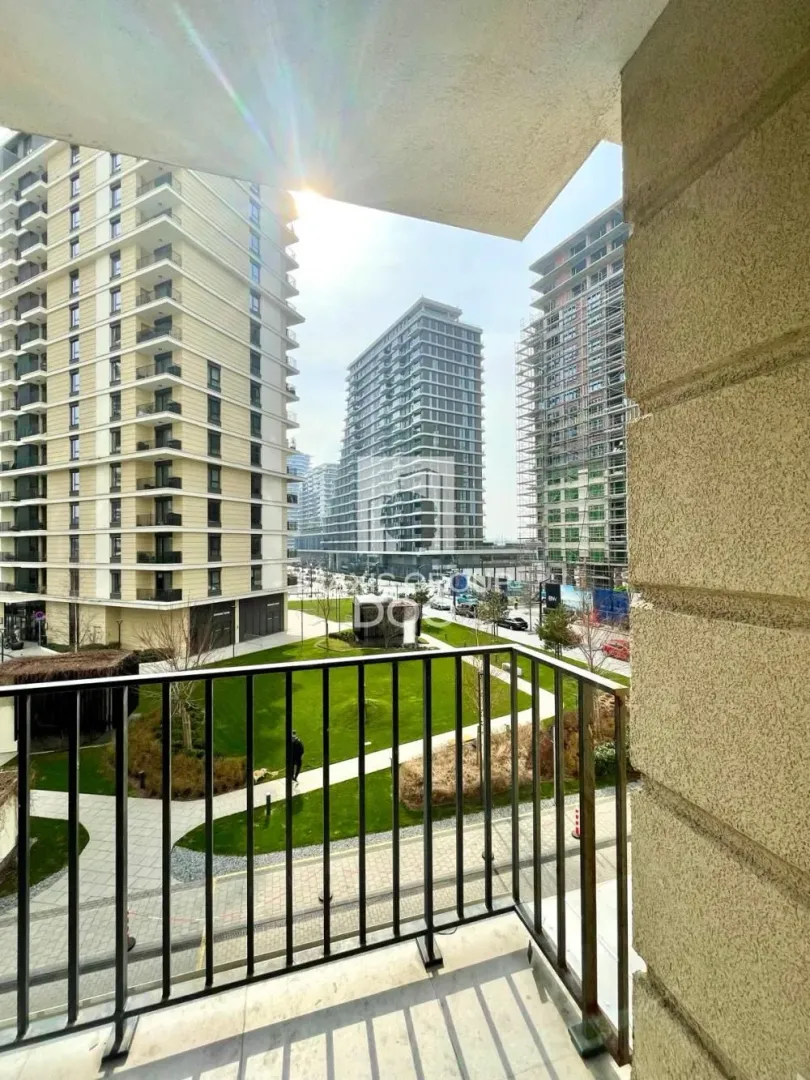 View from the balcony overlooking surrounding buildings and a landscaped courtyard.