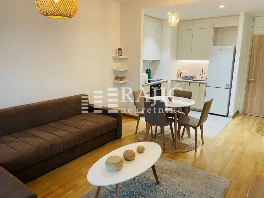Modern living room with dining area and open-plan kitchen.
