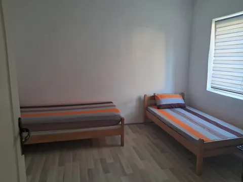 Bedroom with two wooden beds and a window. - image 4