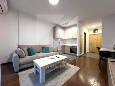 Living room with sofa and a view of the kitchen in the background. - image 3