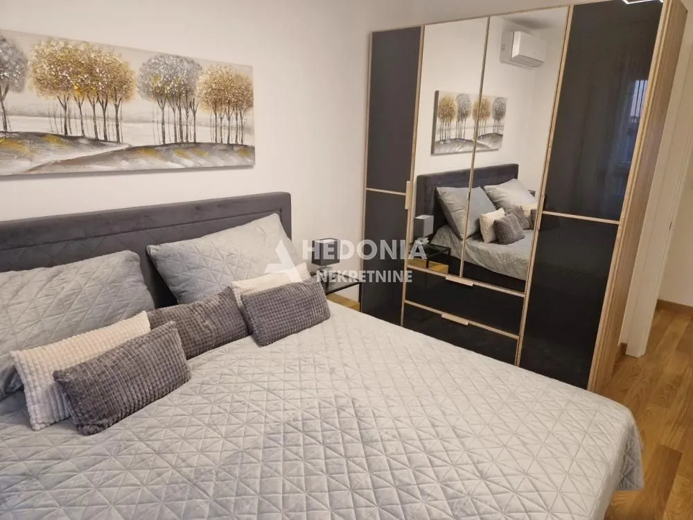 Furnished bedroom with a double bed and a large wardrobe.