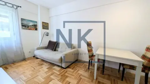 Living room with a sofa, dining table, and parquet flooring. - image 4