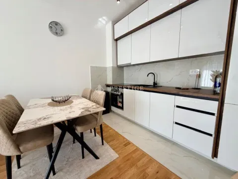 Modern kitchen with dining table and white cabinetry. - image 6