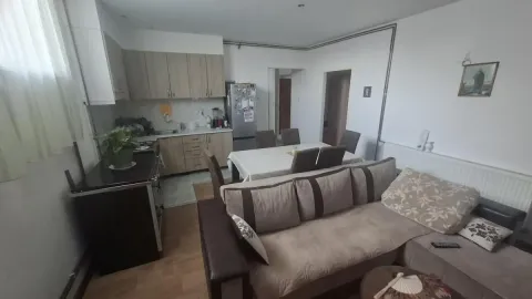 Pogled na dnevni boravak sa garniturom, trpezarijom i kuhinjom u pozadini. - image 6