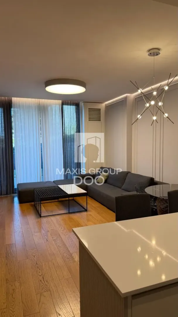 Living room with a sofa set, dining table and hardwood flooring.