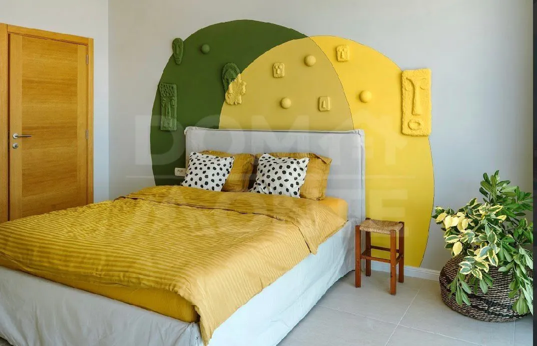 Bedroom with a double bed and a decorative wall.