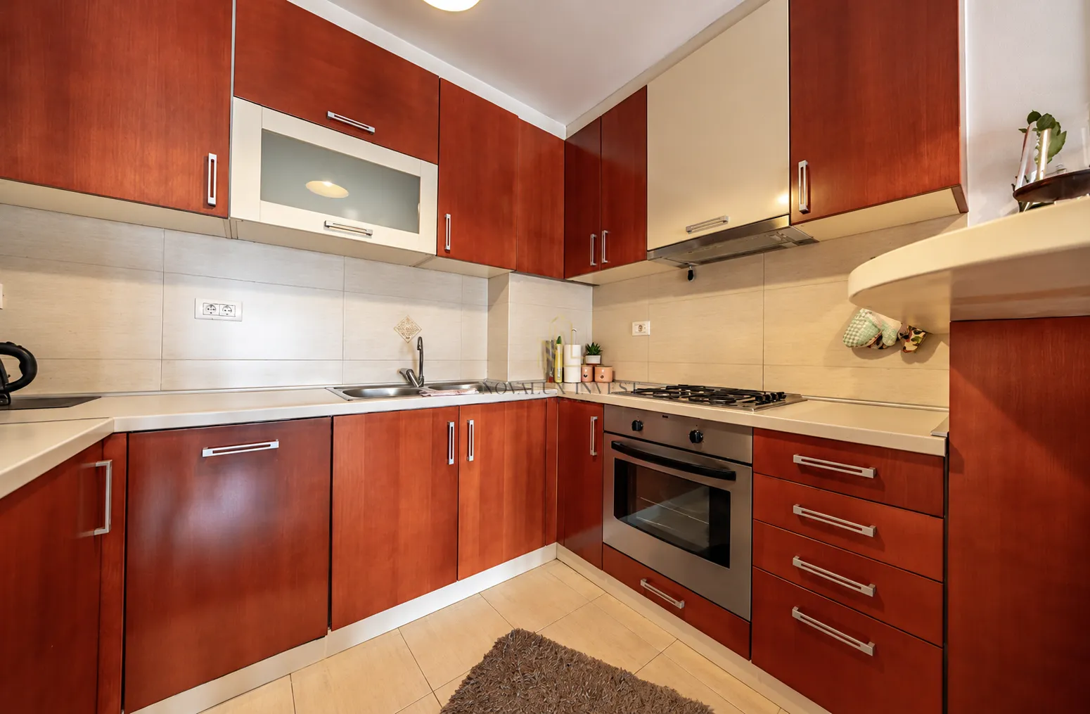 L-shaped kitchen with wooden cabinets and built-in appliances.