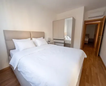 Bedroom with a double bed, mirrored wardrobe, and hardwood flooring. - image 4