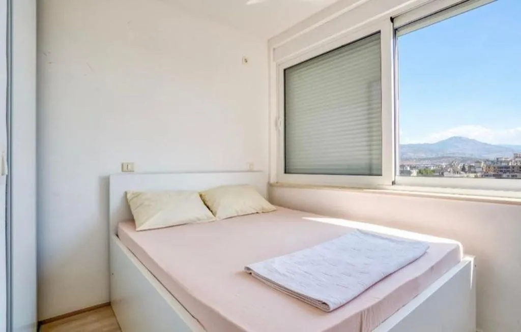 Bedroom with a double bed and a window overlooking the mountains.