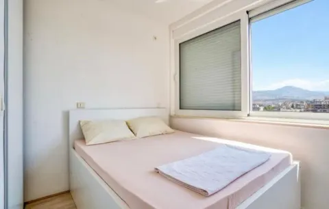 Bedroom with a double bed and a window overlooking the mountains. - image 2