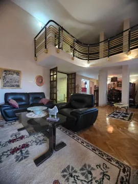 Spacious living room with a sofa set and an upper-level gallery. - image 4