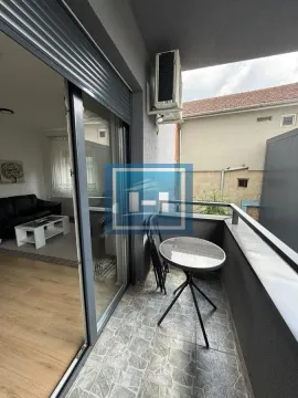 Small furnished balcony with a table and chairs, accessible from the living room. - image 9