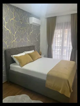 Namještena spavaća soba sa bračnim krevetom i dekorativnim tapetama na zidu. - image 11