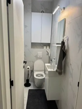 Small modernly equipped bathroom with white tiles and built-in fixtures. - image 10