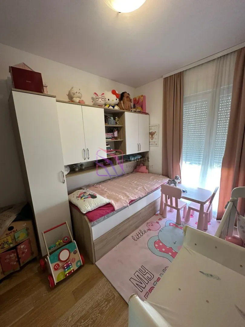 Dječija soba sa krevetom, garderoberom, radnim stolom i igračkama.